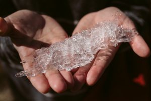 Hand holding a piece of melting Glacial ice