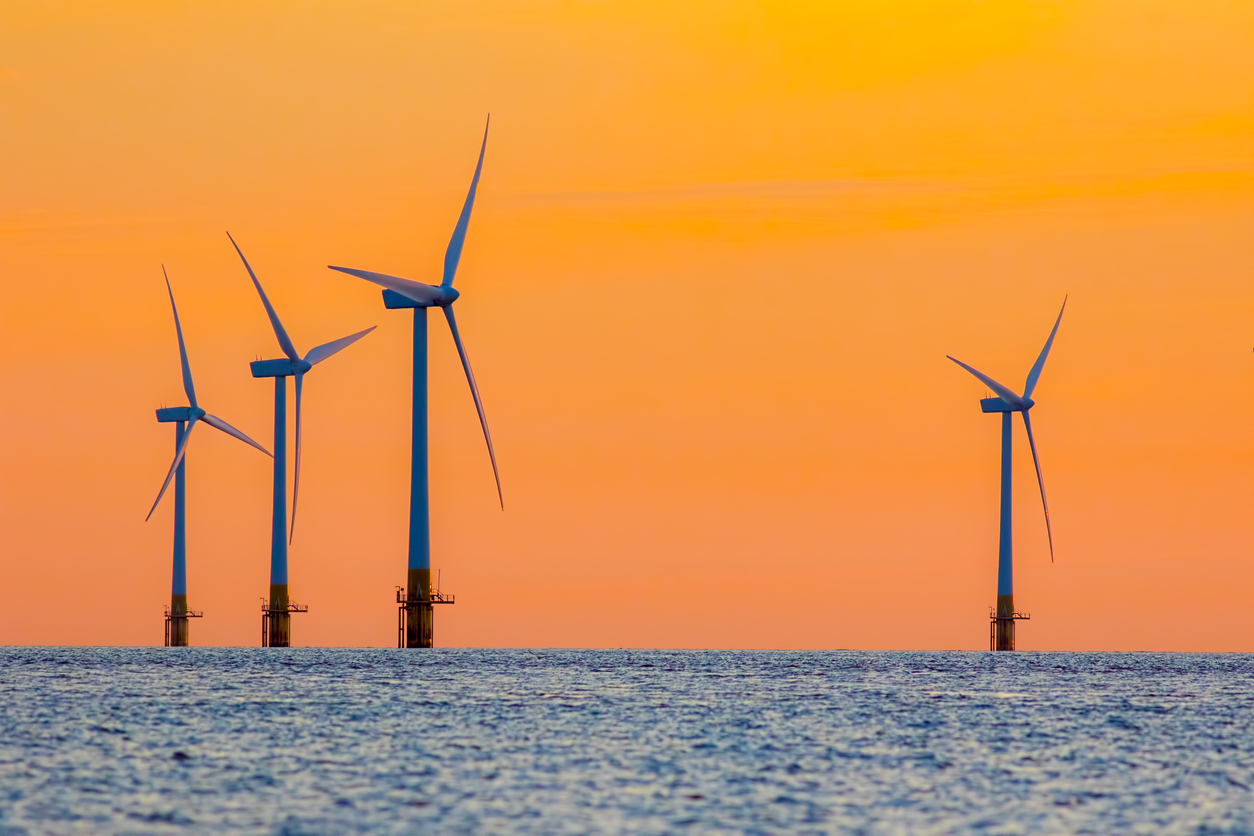 Offshore wind farm energy turbines at dawn. Surreal but natural sunrise at sea.